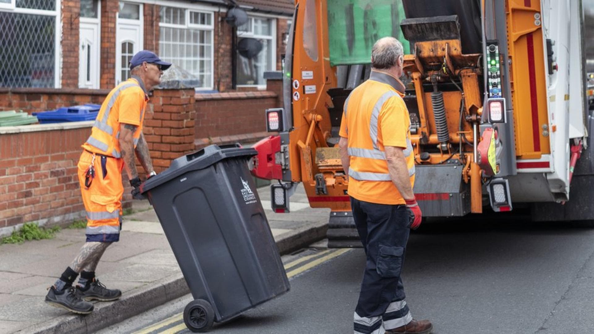 Professional refuse collection crew working at a collection vehicle